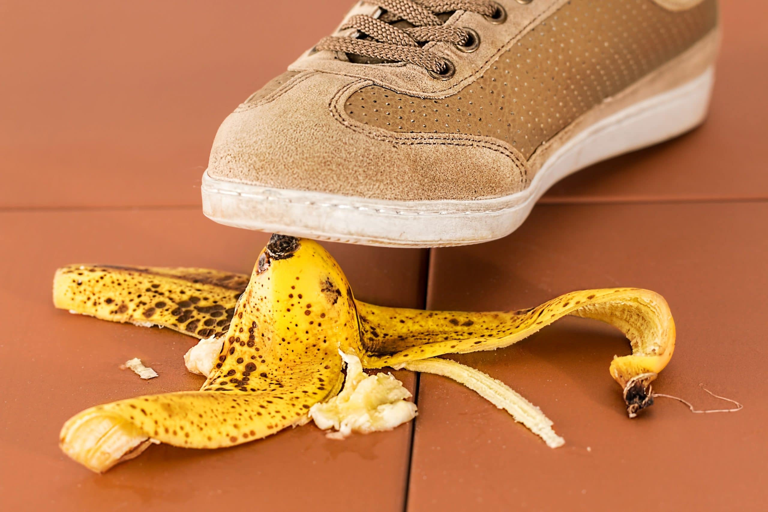 Photo of a shoe about to slip on a banana peel, implying there is going to be a slip and fall accident shortly