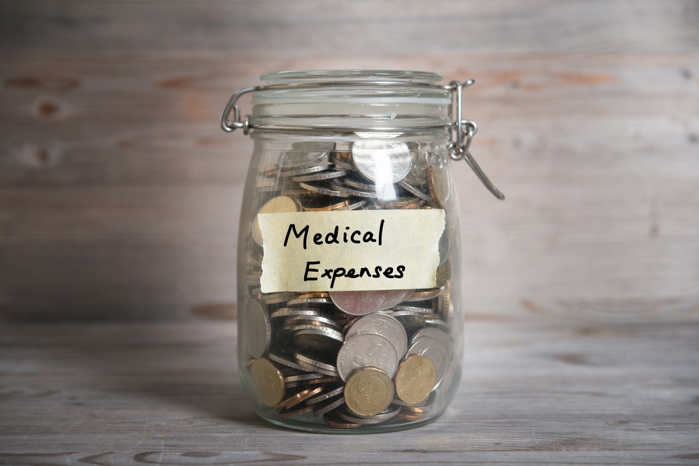 Jar labeled Medical Expenses filled with coins, symbolizing saving for injury costs