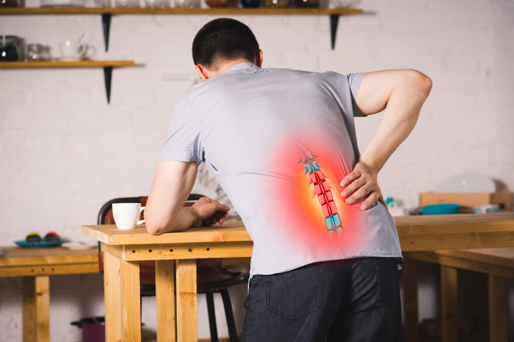 Man with highlighted back pain at desk